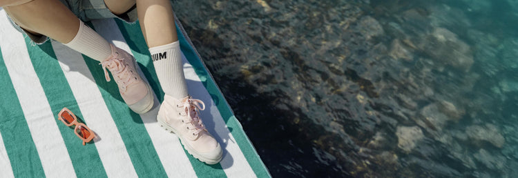 Woman wearing Palladium Pampa Hi boots on a dock near water