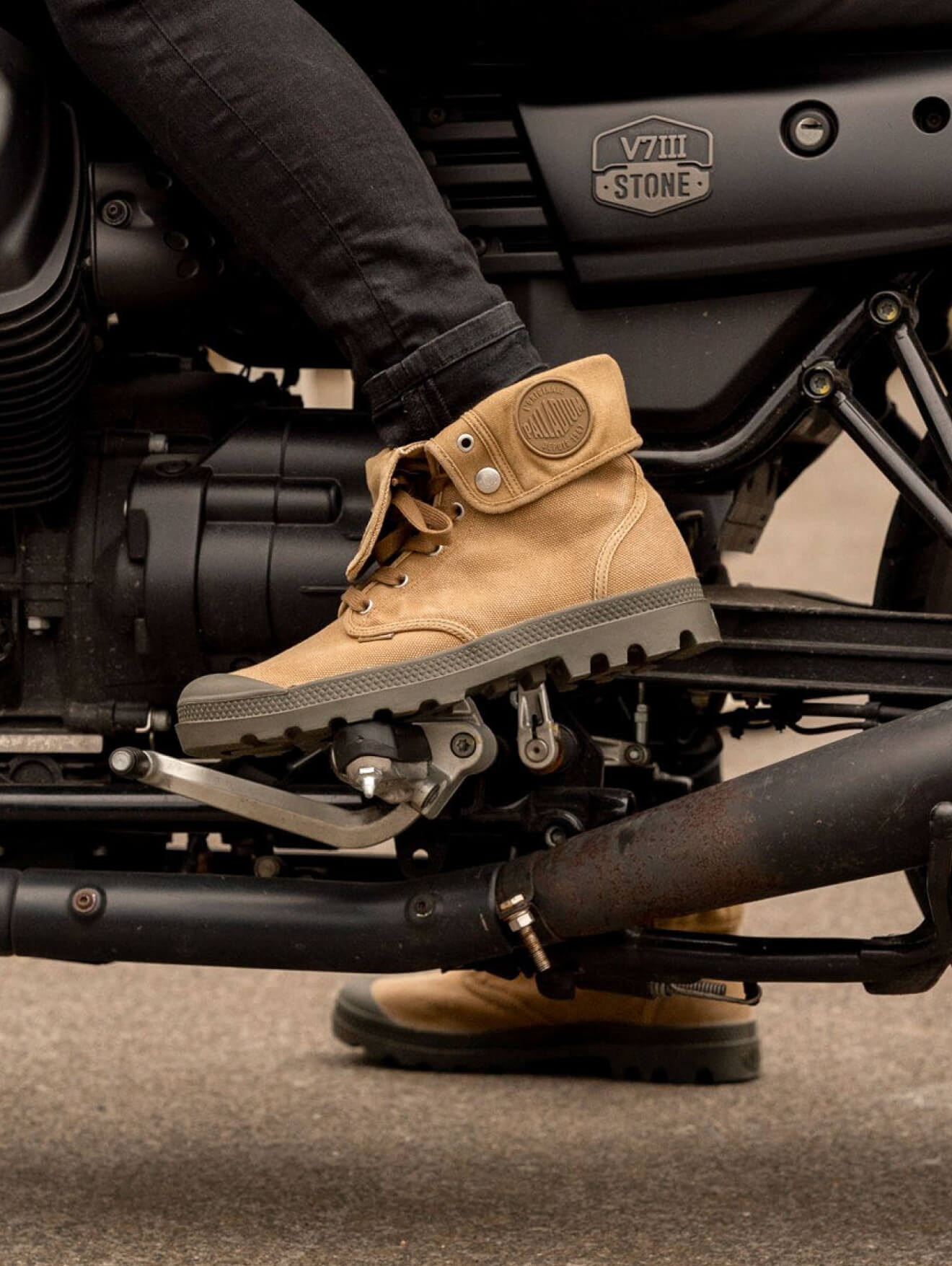 A man siting on bike wearing boots