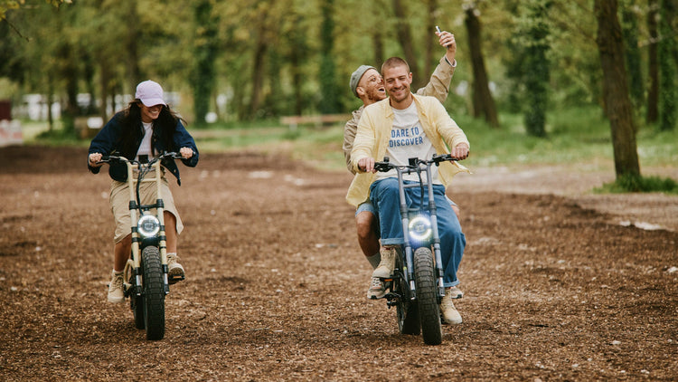 Group of friends riding motorbikes on a dirt path wearing Palladium shoes. 