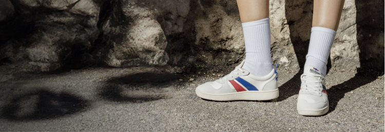 Someone wearing Palladium Pallacup Flame leather sneakers on a sunny sidewalk